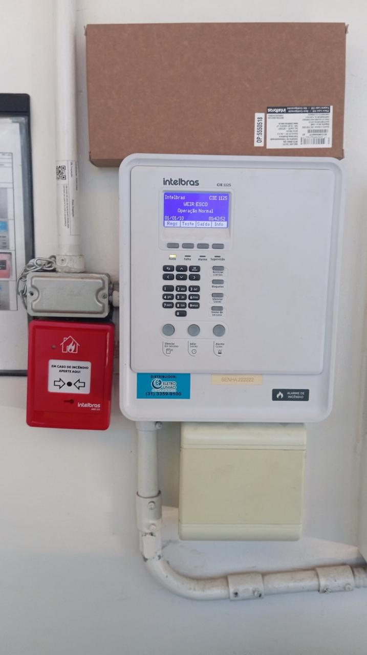 Manutenção preventiva em central de alarme de incêndio Intelbras com acionador manual em planta industrial