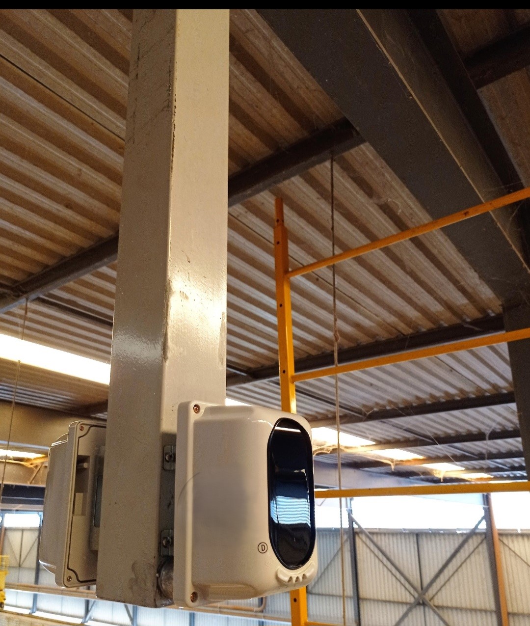 Detector linear de fumaça por feixe óptico instalado em galpão industrial