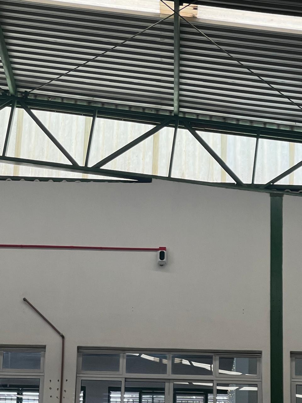 Detector de fumaça em galpão com tubulação vermelha alimentando o ponto